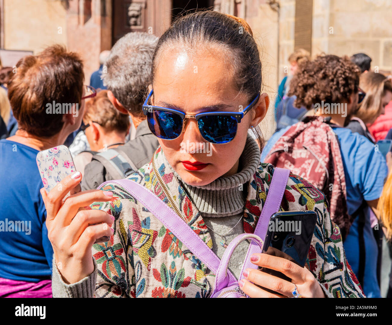 Tourist holding two smartphones, Old Town Square, Prague, Czech Republic Stock Photo