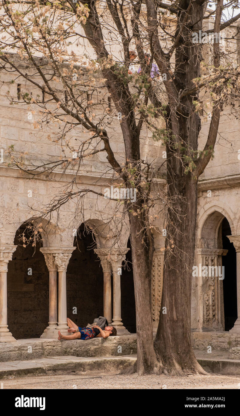 Woman lying down on stone ledge in church, Arles, France Stock Photo