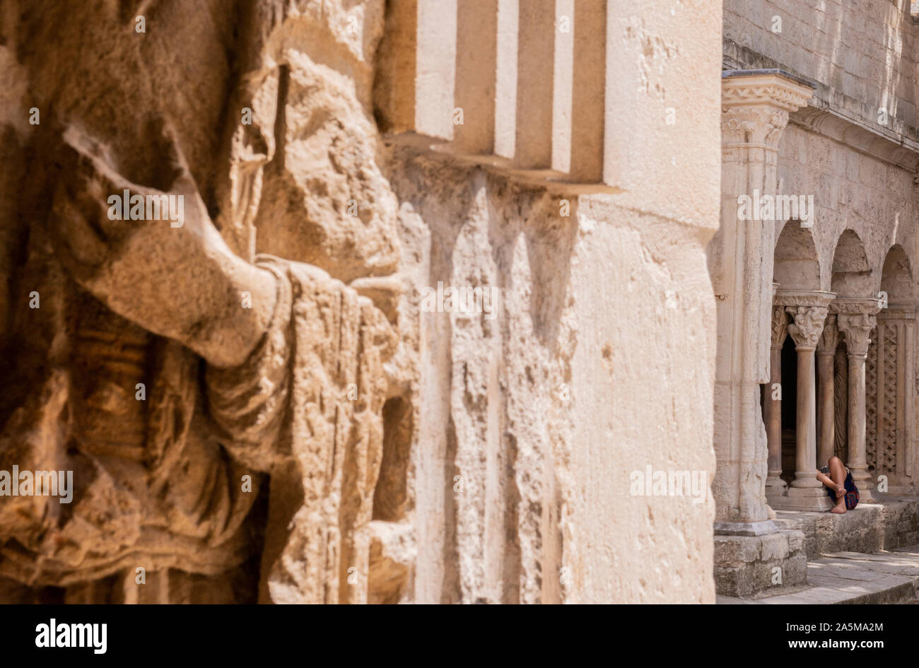 Woman lying down on stone ledge in church, Arles, France Stock Photo