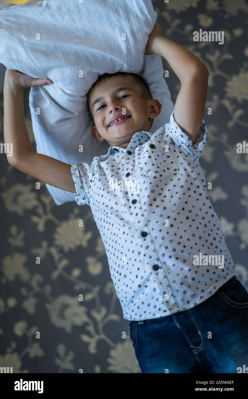 6 years old boy playing pillow fight game Stock Photo
