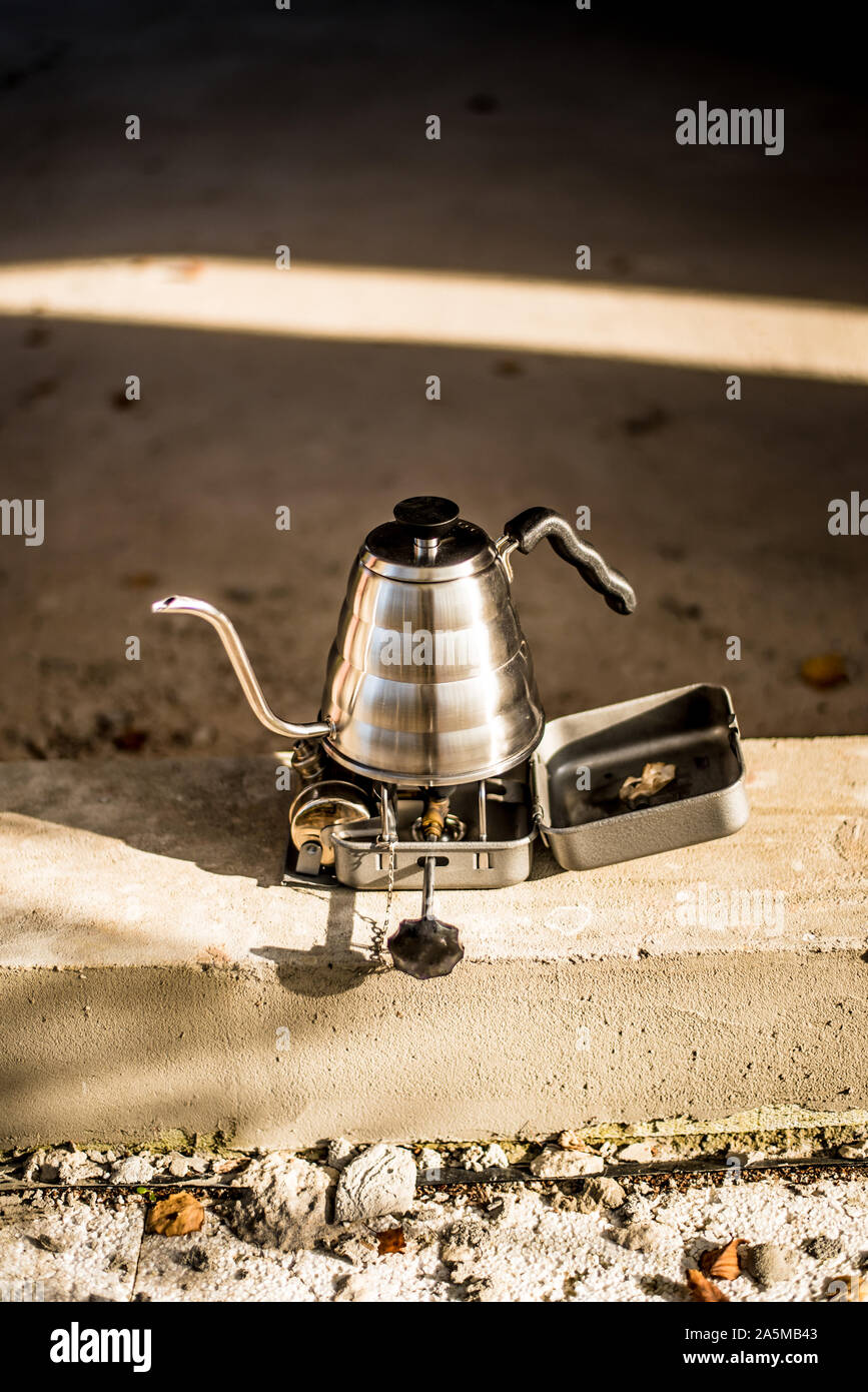 https://c8.alamy.com/comp/2A5MB43/aluminium-drip-kettle-for-coffee-brewing-on-the-tourist-burner-at-the-construction-site-concrete-background-2A5MB43.jpg