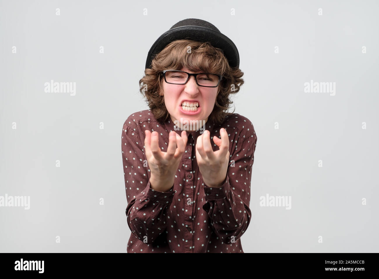 Angry caucasian woman in hat and glasses screaming Stock Photo