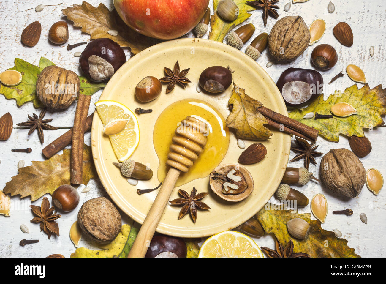 Autumn composition with nuts, honey, seeds, spices, acorns, chestnuts, fruits and autumn leaves. Top view, flat lay. Stock Photo