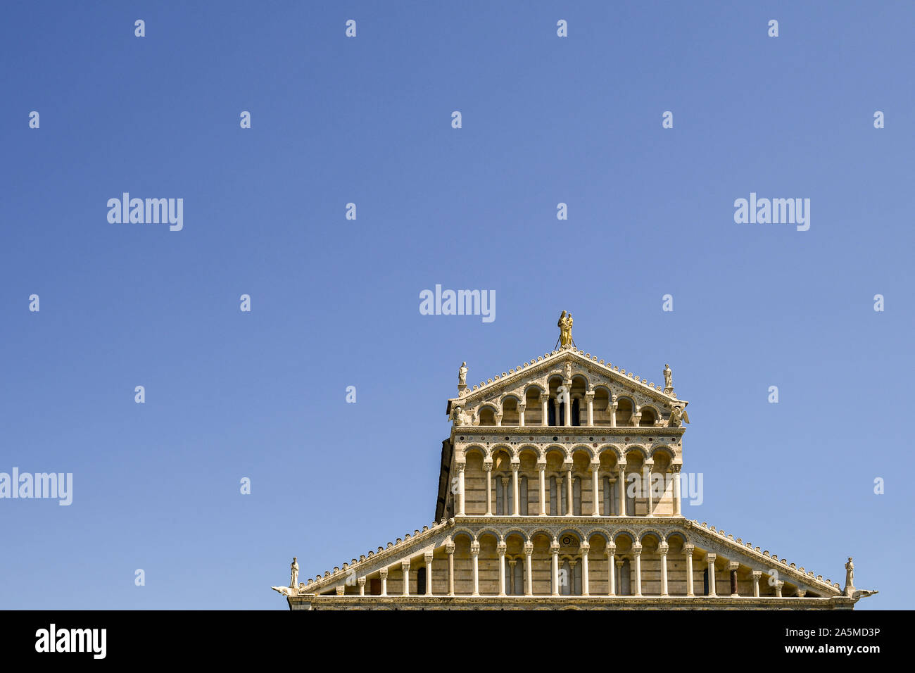 Top exterior of the façade of Pisa Cathedral (Duomo di Santa Maria Assunta) in the famous Piazza dei Miracoli against clear blue sky, Tuscany, Italy Stock Photo