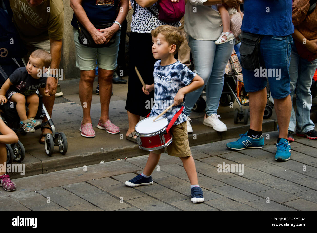 A boy playing a drum at the Giants Parade during La Merce Festival 2019 at Placa de Sant Jaume in Barcelona, Spain Stock Photo