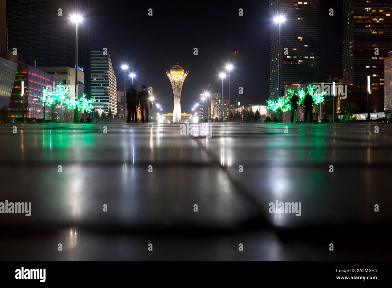NUR-SULTAN - The Nurzhol Boulevard with the Bayterek tower and plastic trees at night. Stock Photo