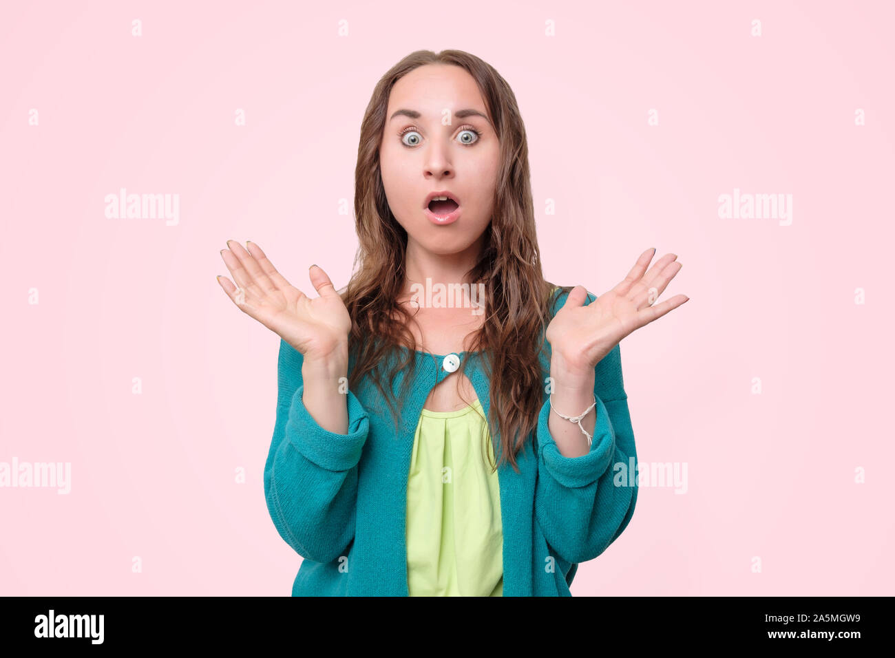 Woman with opened mouth and big eyes holding hands near face and looking happy Stock Photo