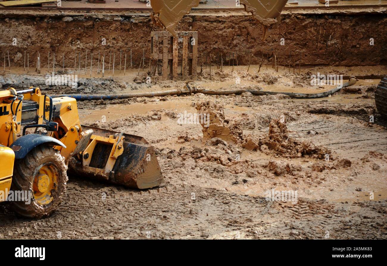 a yellow digger excavating mud Stock Photo