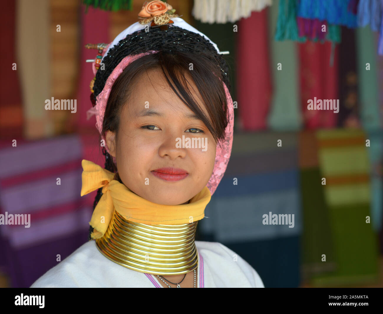 Young Myanmarese Kayan Lahwi longneck woman (“giraffe woman”) with tribal Padaung brass neck rings/coils poses for the camera. Stock Photo