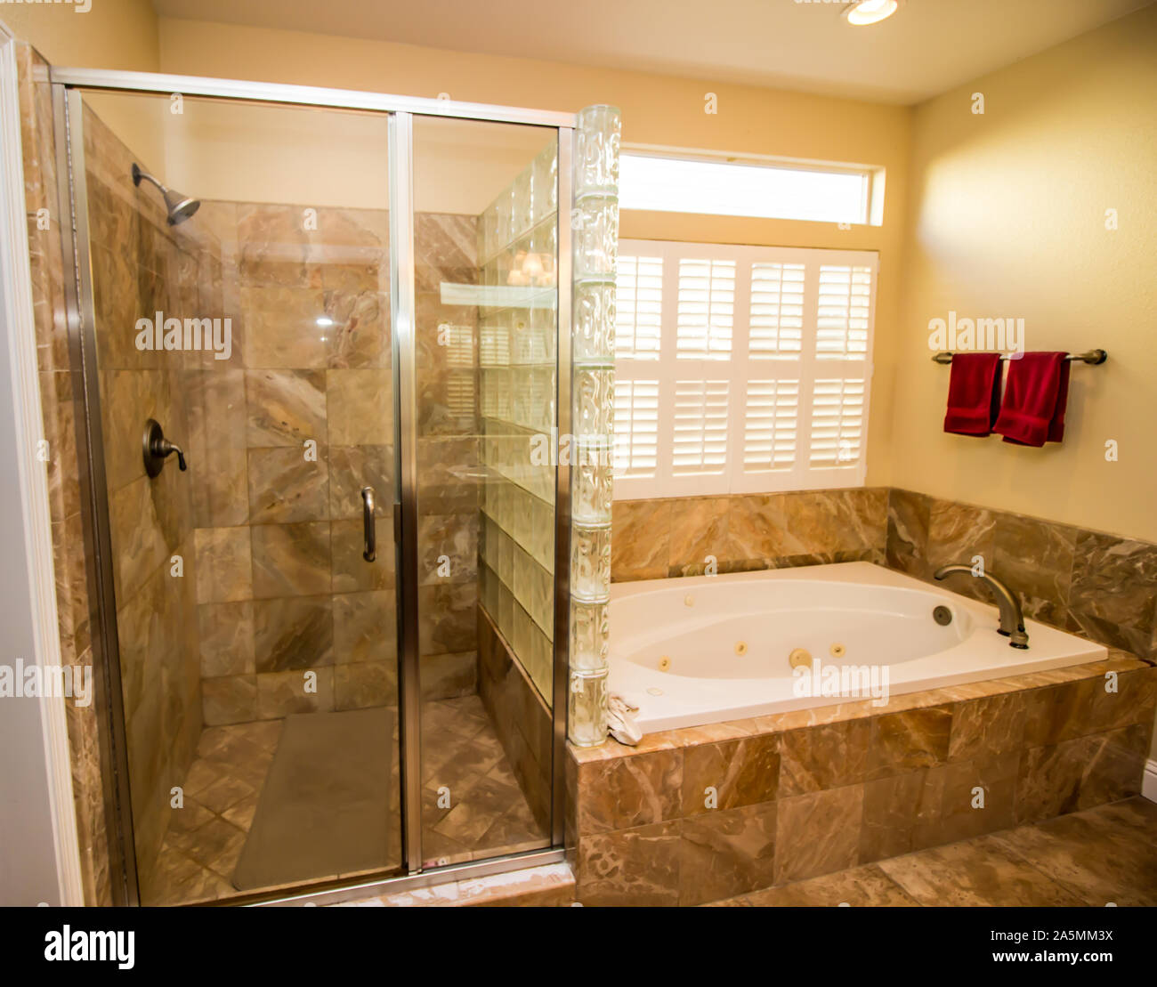 Modern Bathroom With Jacuzzi Tub & Bottle Glass Shower Stock Photo