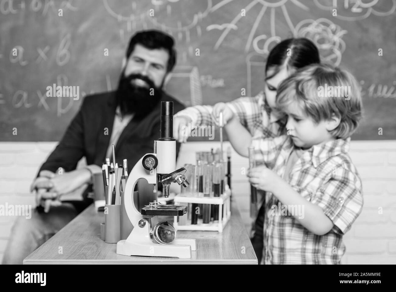 students doing science experiments with microscope in lab. back to school. school kids scientist study science. happy children. Little kids learning chemistry in school laboratory. Discovering cure. Stock Photo