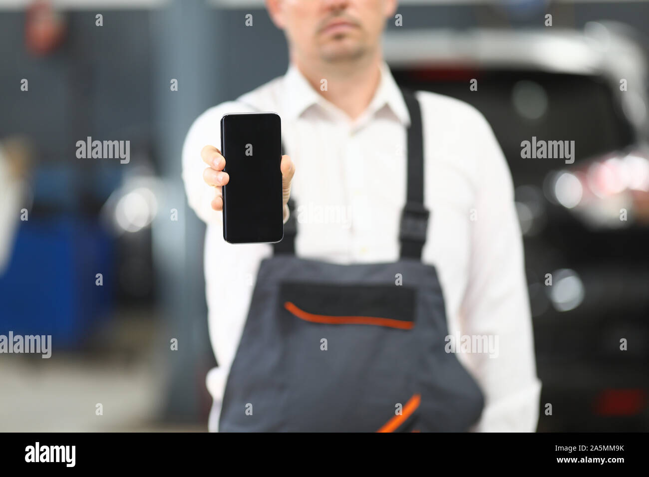 Male in working clothes showing gadget Stock Photo