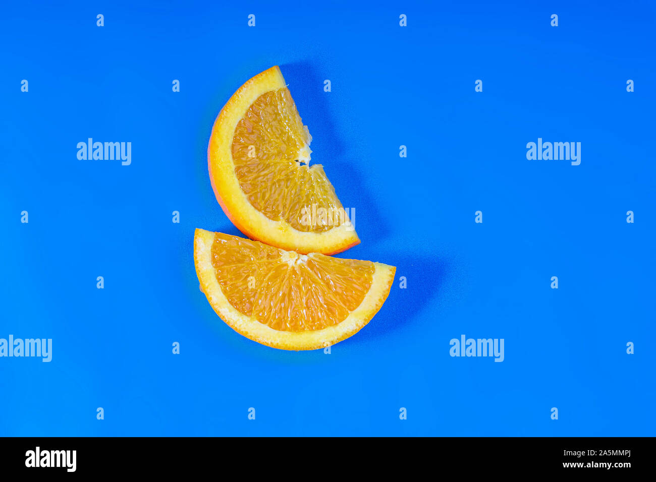 Orange fruit slides on a blue background Stock Photo
