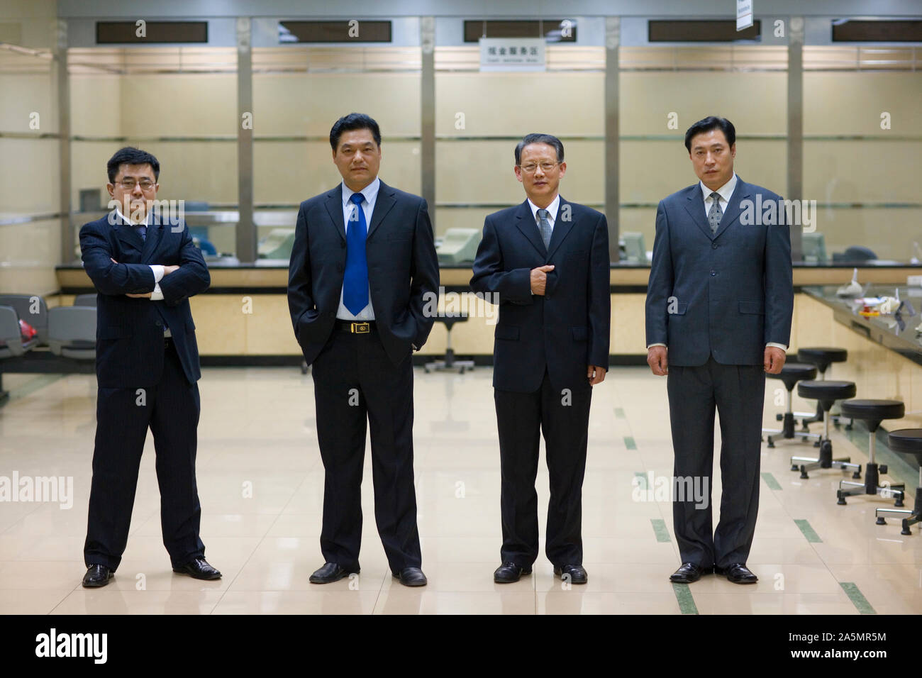 Portrait of four well-dressed businessmen standing side by side Stock ...