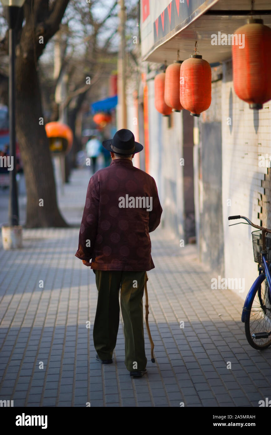 Senior man walking with a cane down an urban street Stock Photo - Alamy
