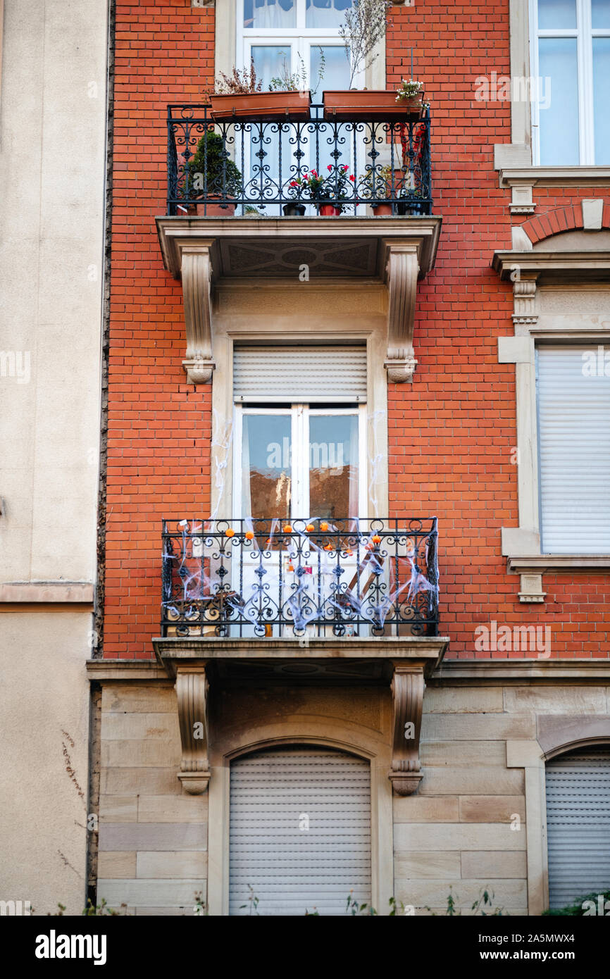 Beautiful French balcony decorated with little pumpkins and fake spider net during Halloween holiday Stock Photo
