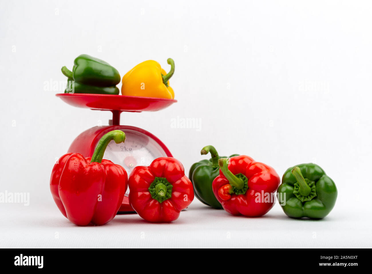 Sweet peppers on red scales market concept on the white background isolated Stock Photo