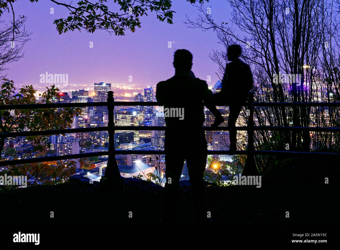 People looking out over Montreal city centre at dusk from a viewpoint on Mont Royal, Canada Stock Photo