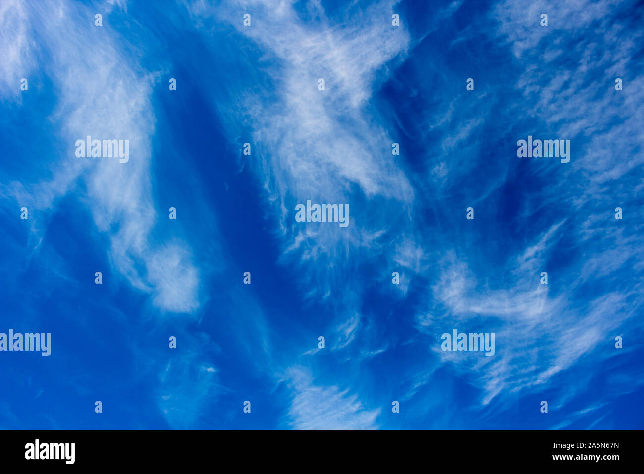 High white wispy cirrus cirro-stratus clouds in a blue Australian sky sometimes called mare's tails indicate fine weather now but storms coming soon. Stock Photo