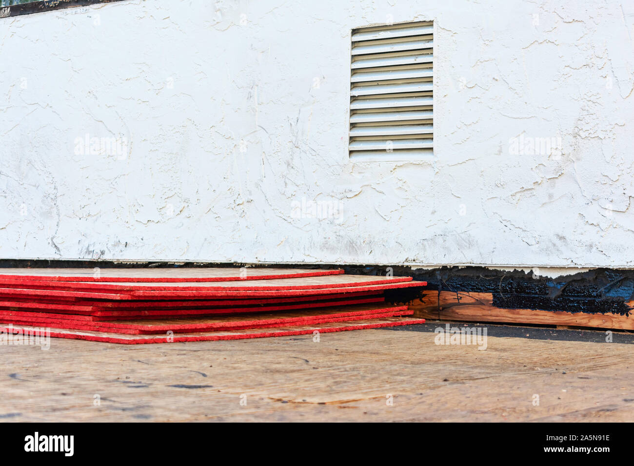 Flat roof repair and replacement in progress. Sheets of stacked plywood on roof sheathing. Stock Photo