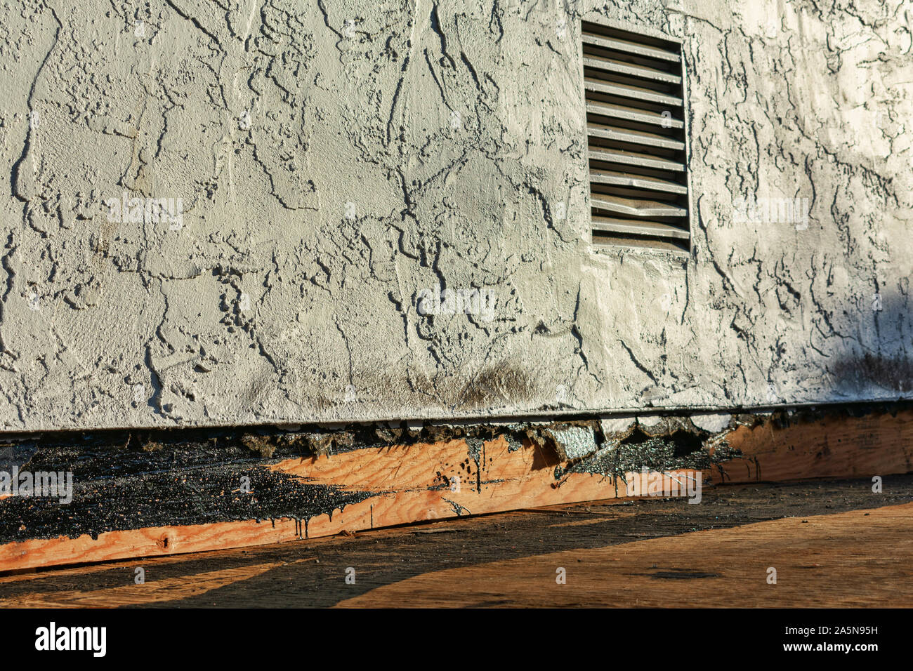 Roof repair and replacement work in progress. Stucco sidewall and flat