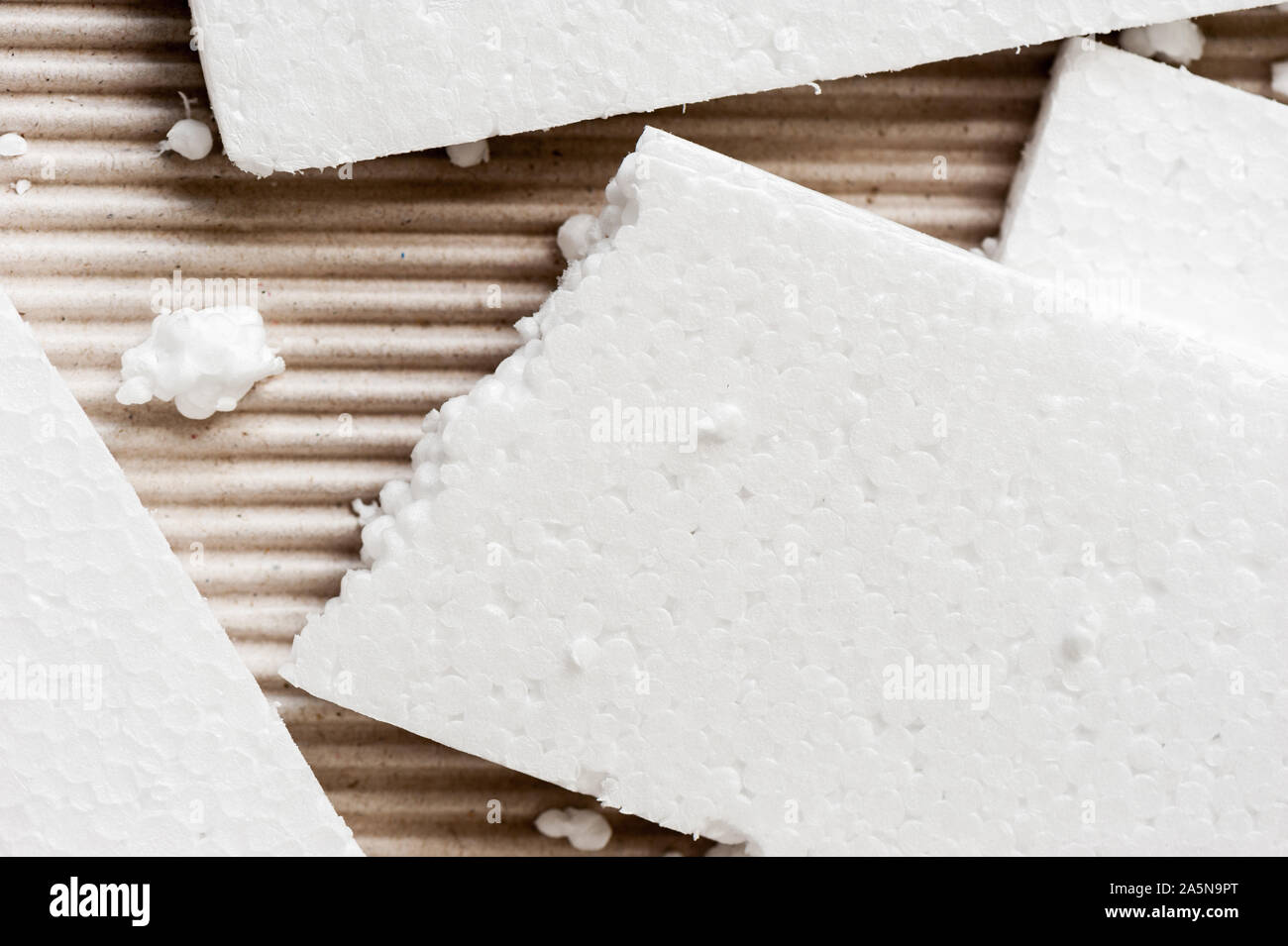 Closeup white polystyrene foam on corrugated paper. Polystyrene foam is ...