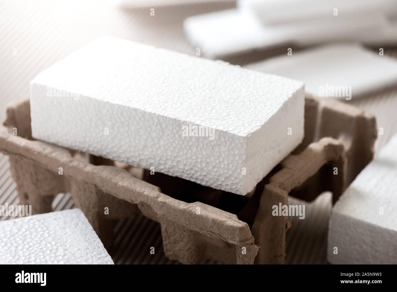 Closeup white polystyrene foam on corrugated paper. Polystyrene foam is ...