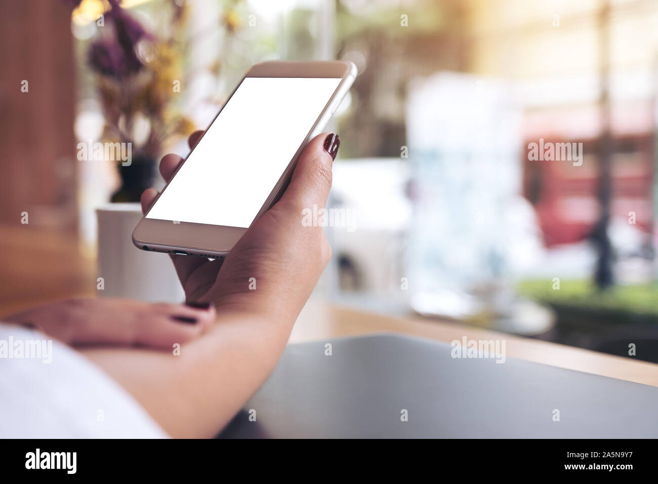 Mockup image of a woman's hand holding white mobile phone with blank ...