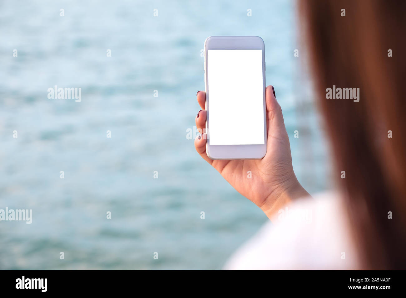 Mockup image of a woman's hand holding white mobile phone with blank ...