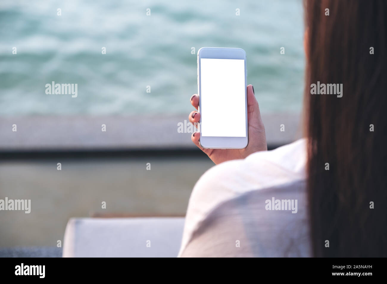 Mockup image of a woman holding white mobile phone with blank desktop ...