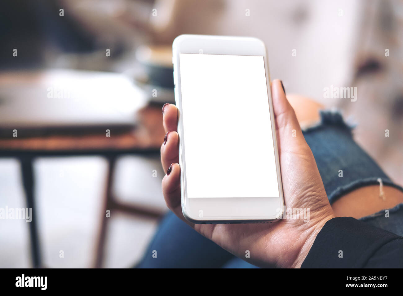 Mockup image of a woman's hand holding white mobile phone with blank ...