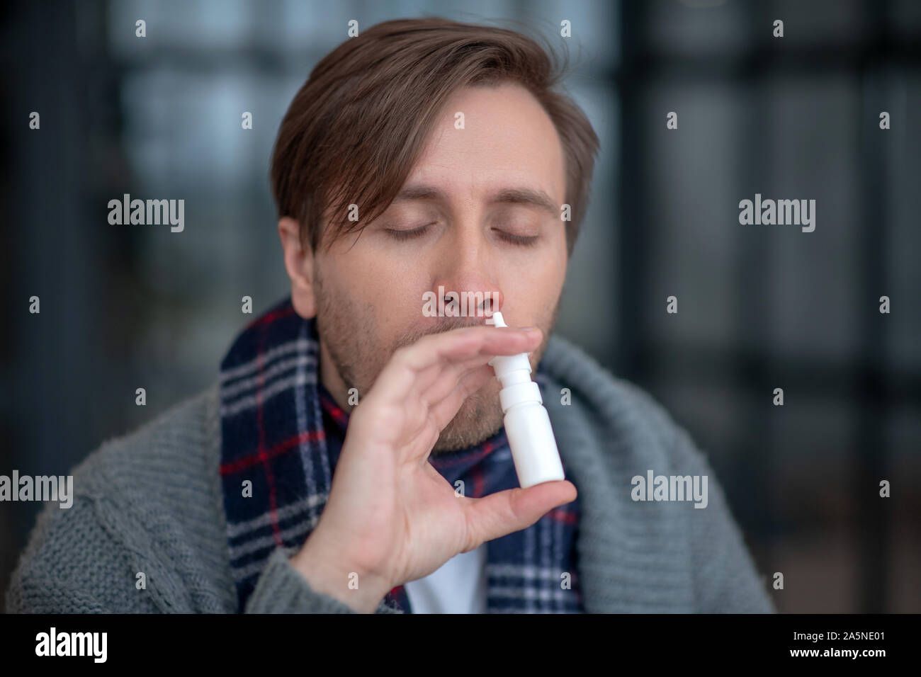 Man using nasal spray suffering from sneezing Stock Photo Alamy