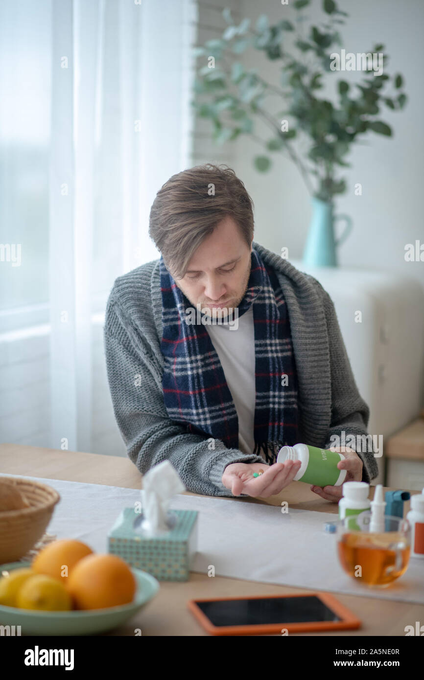 Sick man drinking pills while having high fever Stock Photo Alamy
