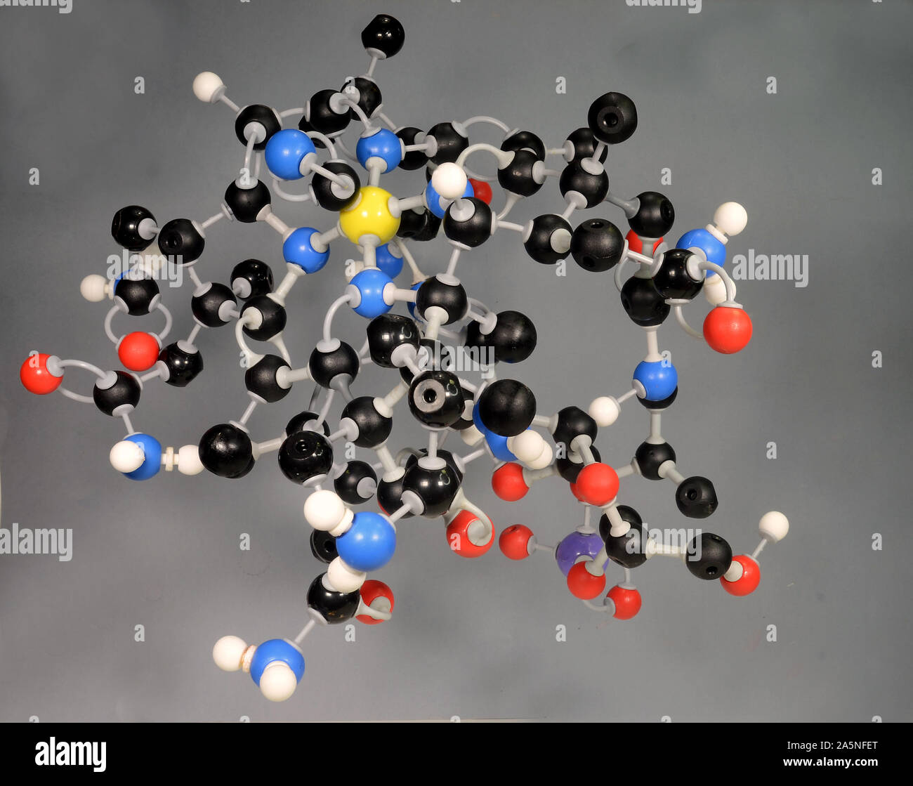 Molecule model of Vitamin B12.   White is Hydrogen, black is Carbon, red is  Oxygen, violet is Phosphorous and yellow is Cobalt. Stock Photo