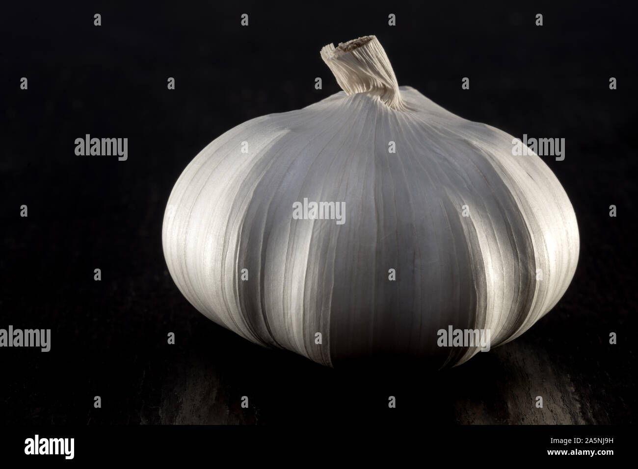 Garlic bulb on dark background table top shot Stock Photo - Alamy