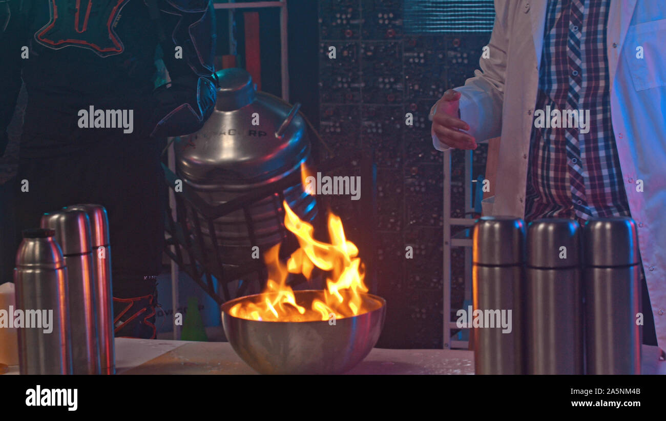 A man is setting fire to chemicals in an iron bowl - indoors Stock Photo