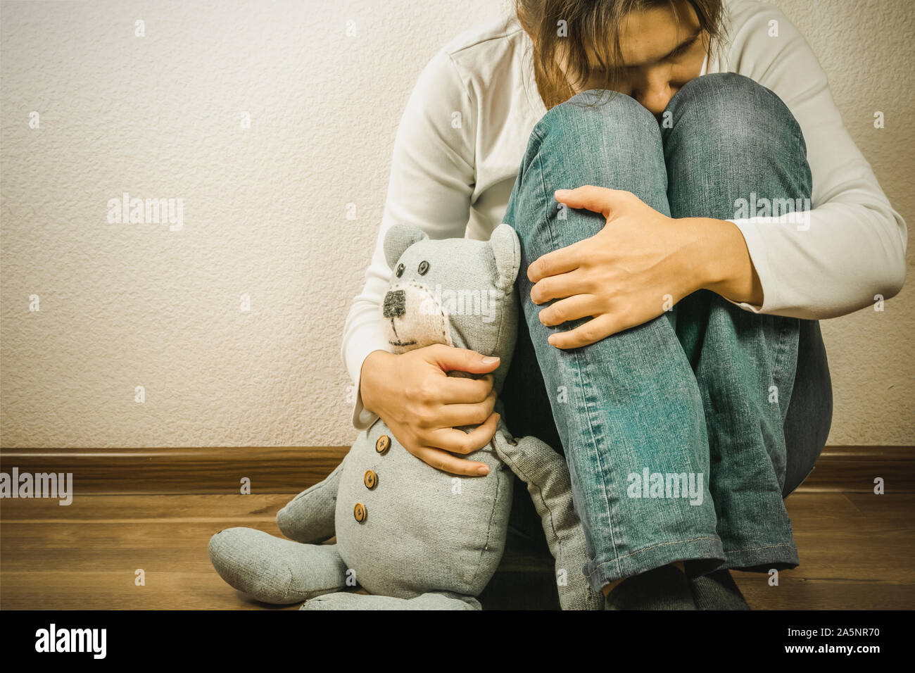 Prenatal loss concept - depressed woman holding teddy bear toy Stock Photo