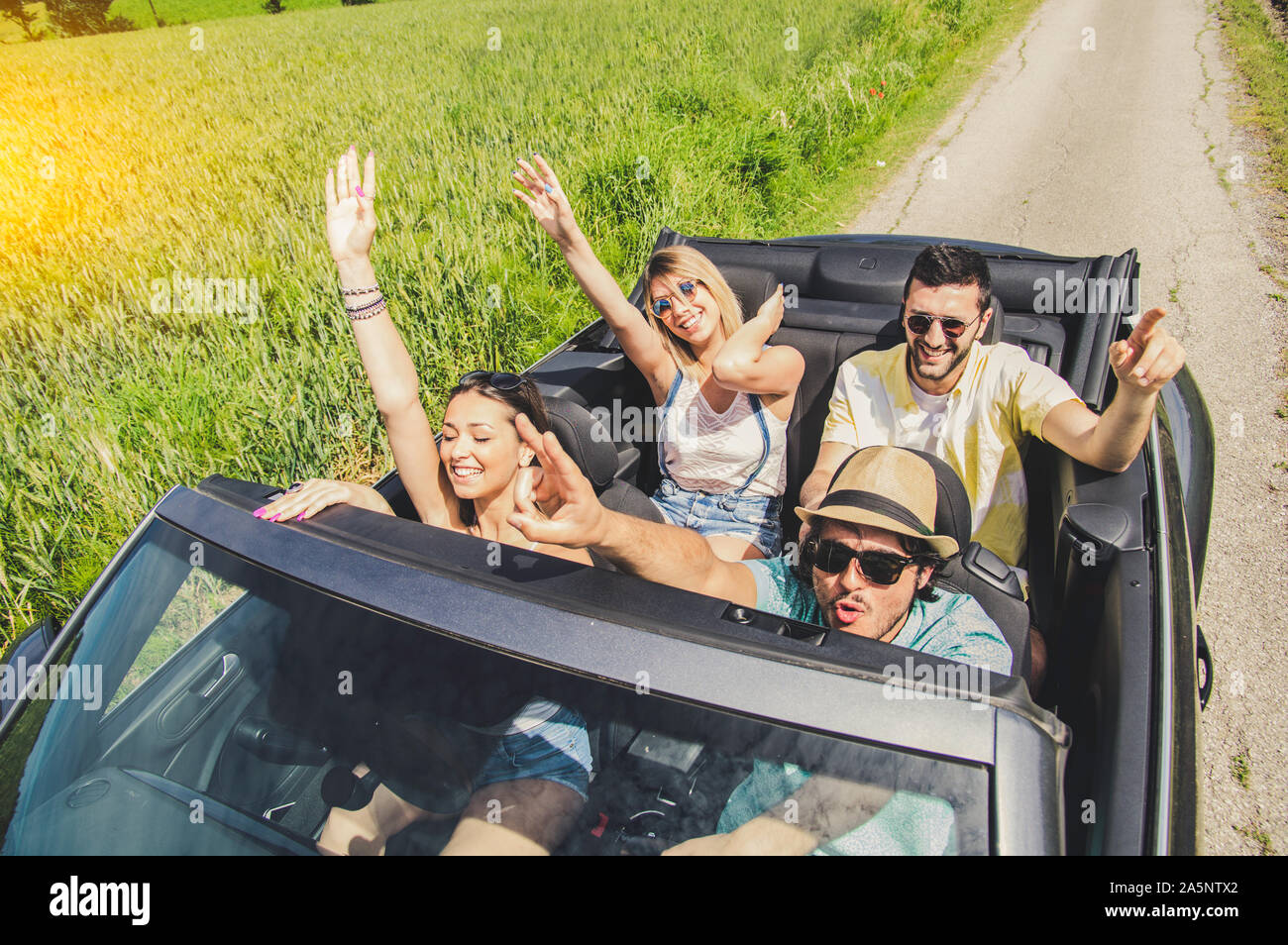 Group of friends having fun at car trip. Four caucasian people on a ...