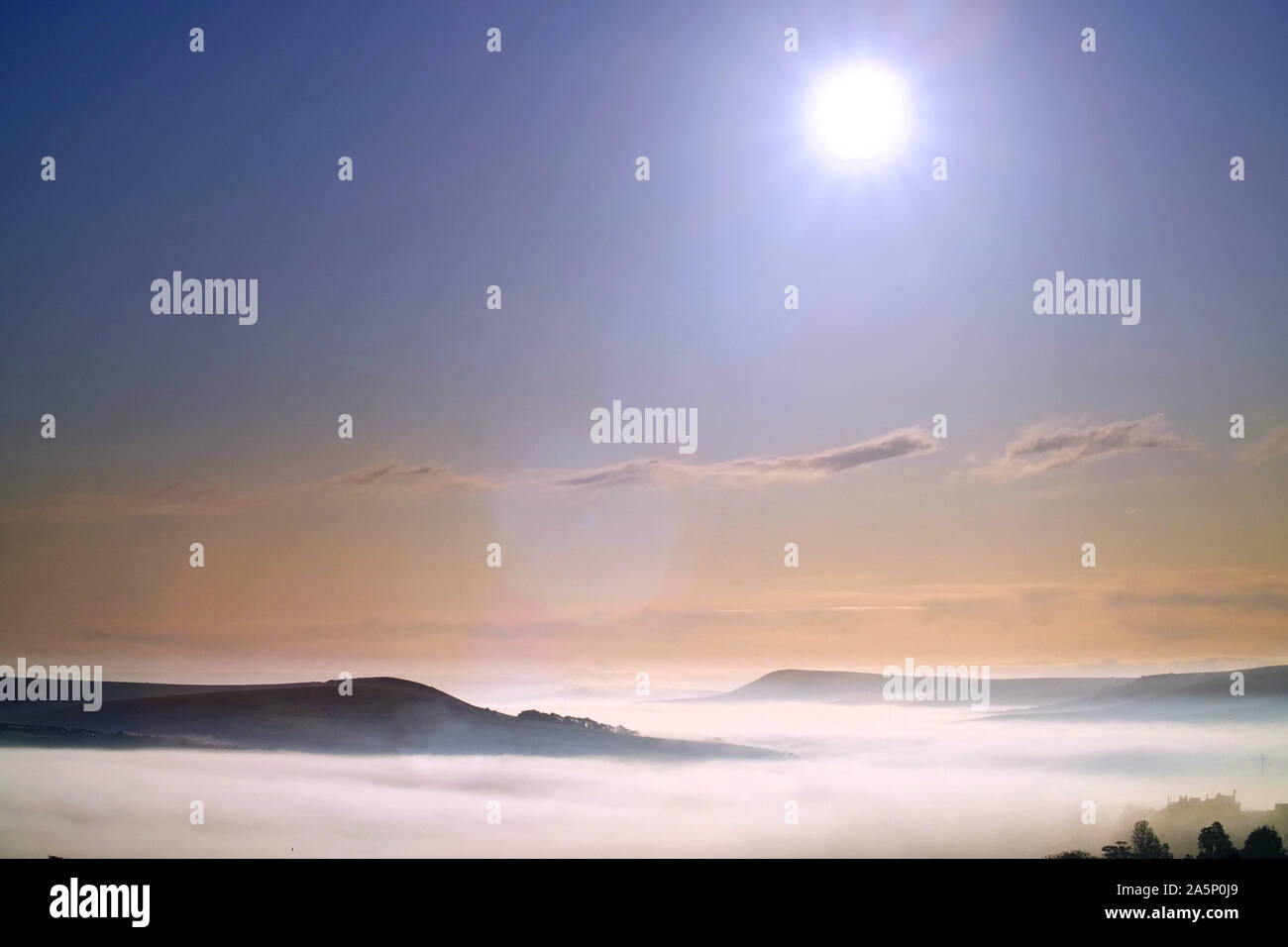 Lewes, East Sussex, UK. 22nd October 2019: A thick blanket of morning mist covers the historic town of Lewes, East Sussex, with only the peaks of the surrounding South Downs national park visible.   © Peter Cripps/Alamy Live News Stock Photo