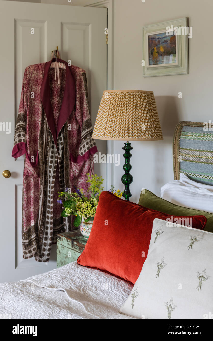 Dressing gown hangs on back of door at bedside. Stock Photo