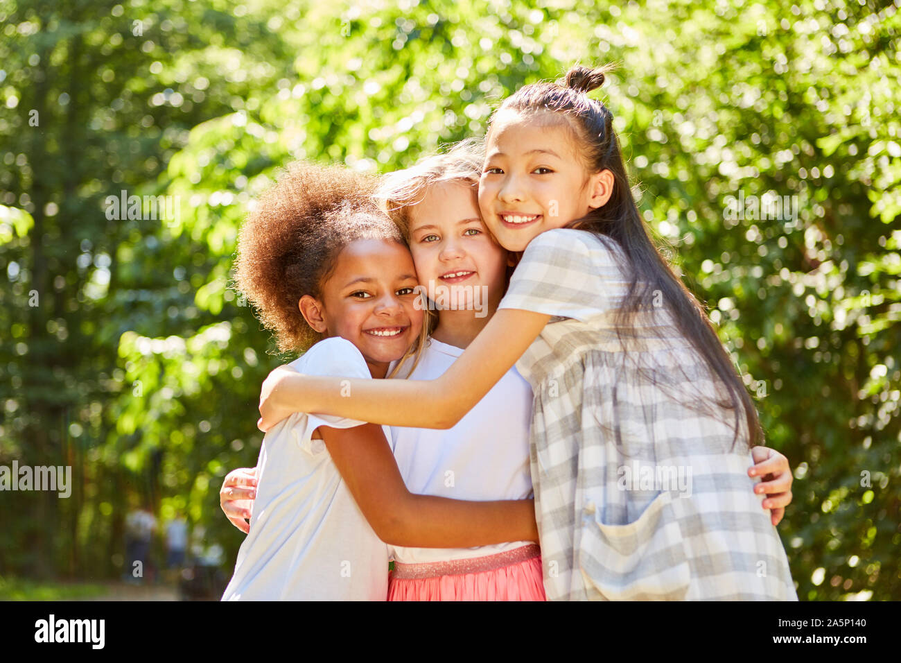 Three multicultural girls hugging each other as best friends Stock Photo