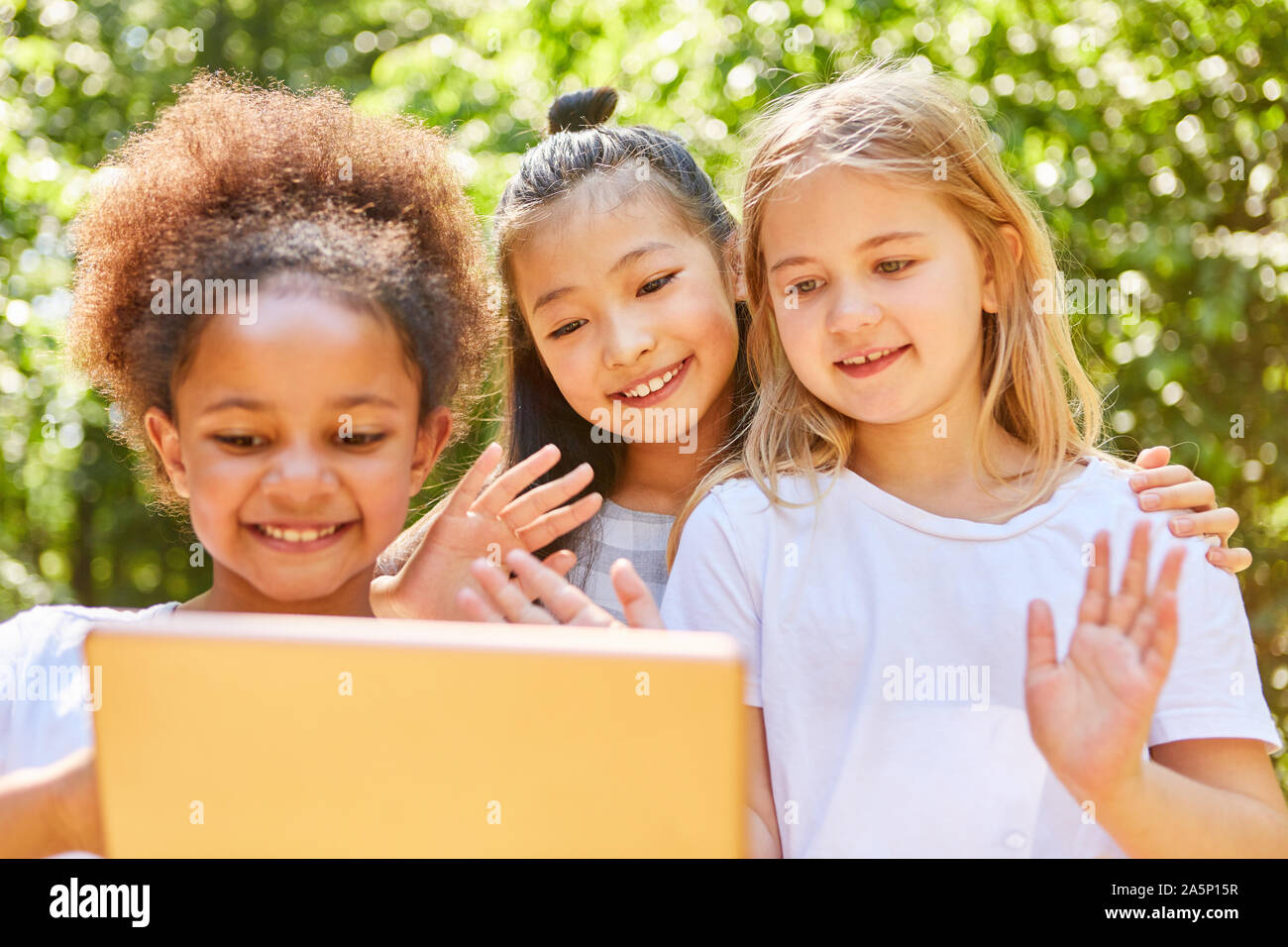 Girls waving together at video chat on tablet computer Stock Photo