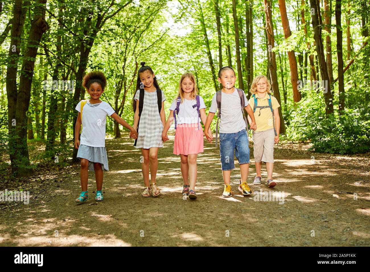 Group of multicultural kids with backpack on hiking day in nature Stock Photo