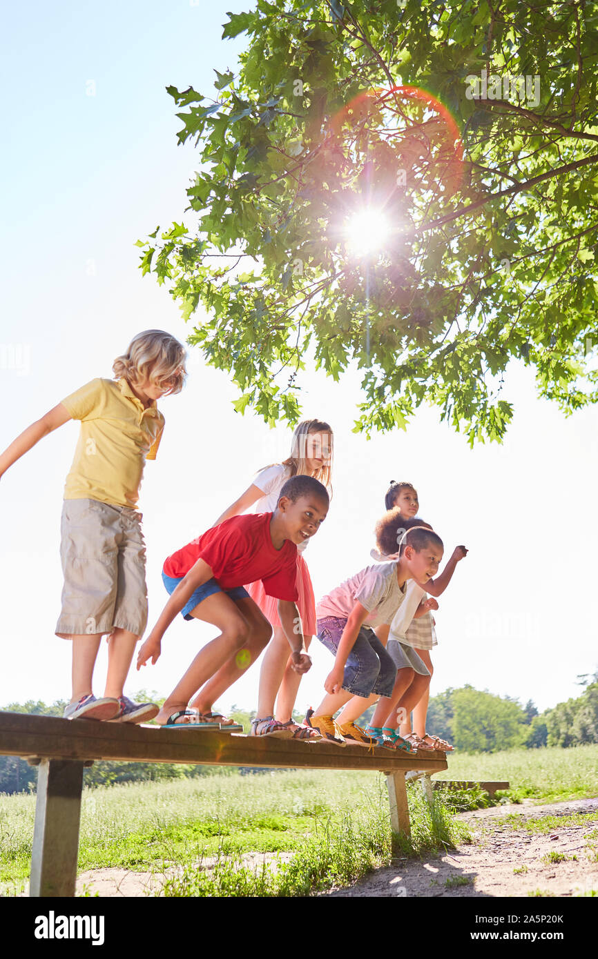 Group of kids jumps from a balance beam on the trim you path Stock Photo