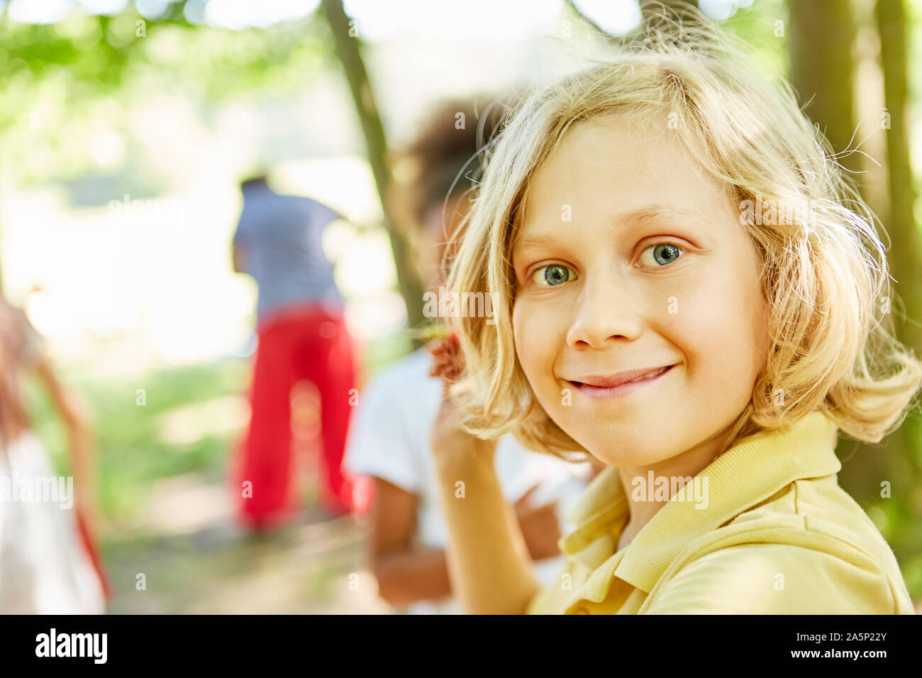 Blond boy in nature on a tour smiles happily Stock Photo