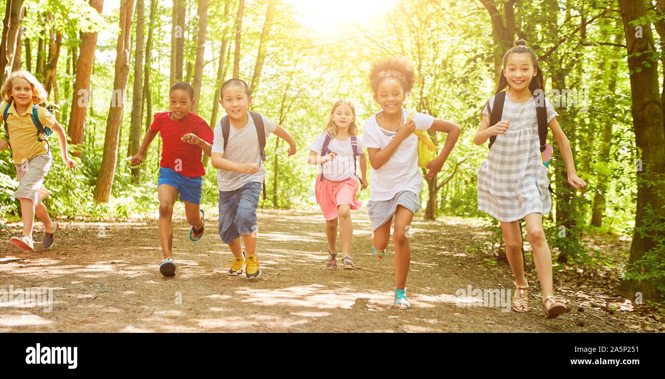 Many children walk a long way during the hiking day in nature in summer Stock Photo