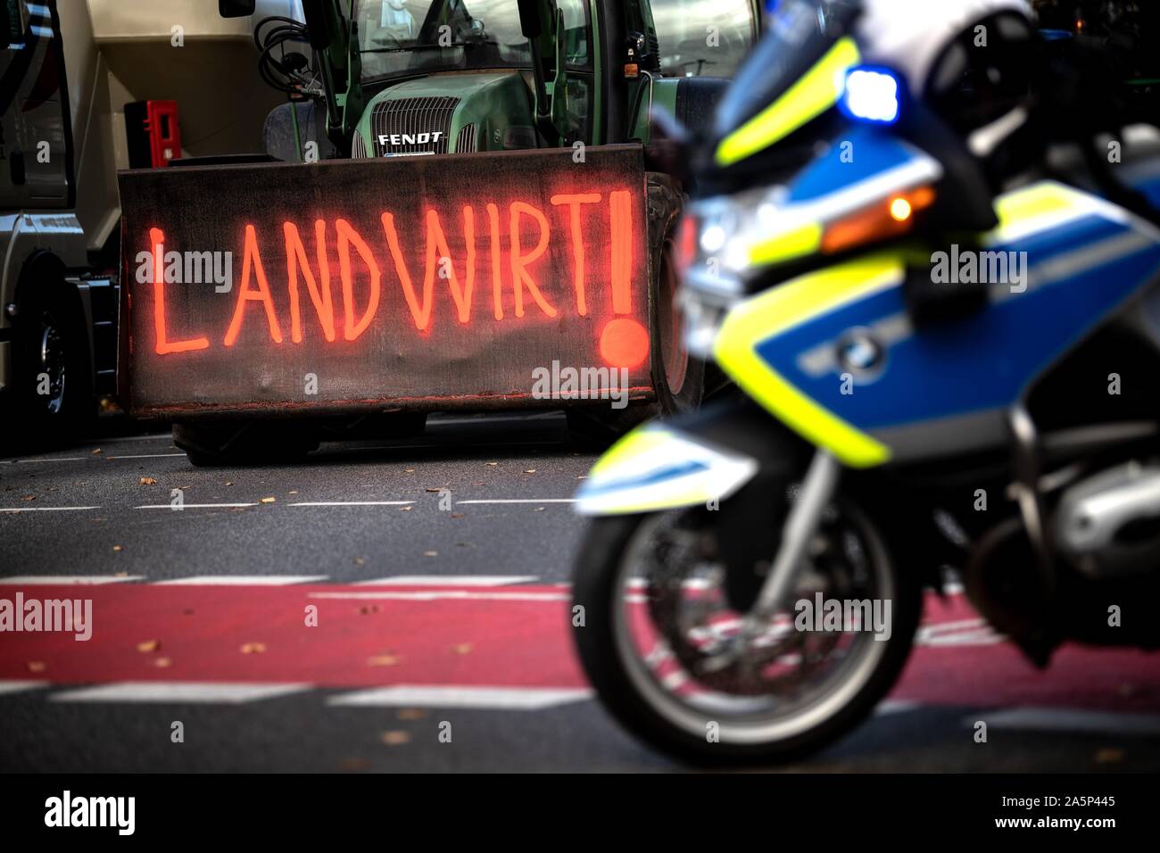 Hanover, Germany. 22nd Oct, 2019. A police motorcycle stands in front of a tractor with the inscription 'Farmer!'. The rally is part of a nationwide campaign by the farmers' initiative 'Land schafft Verbindung', which has been joined by tens of thousands of farmers in a very short space of time. They are protesting against the federal government's agricultural policy. Credit: Sina Schuldt/dpa/Alamy Live News Stock Photo