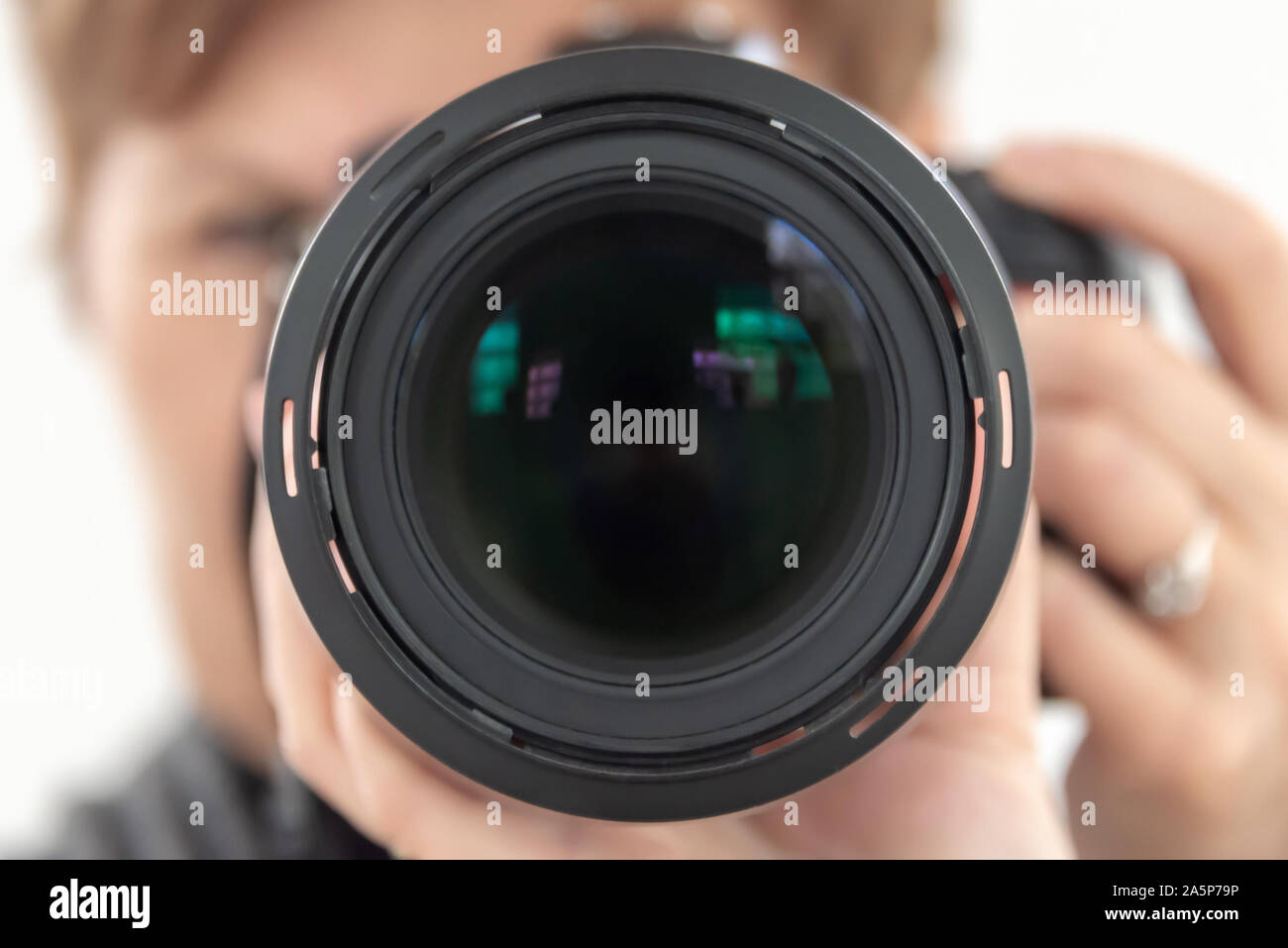 Close up of a DSLR camera lens, blurred hands of woman professional photographer Stock Photo