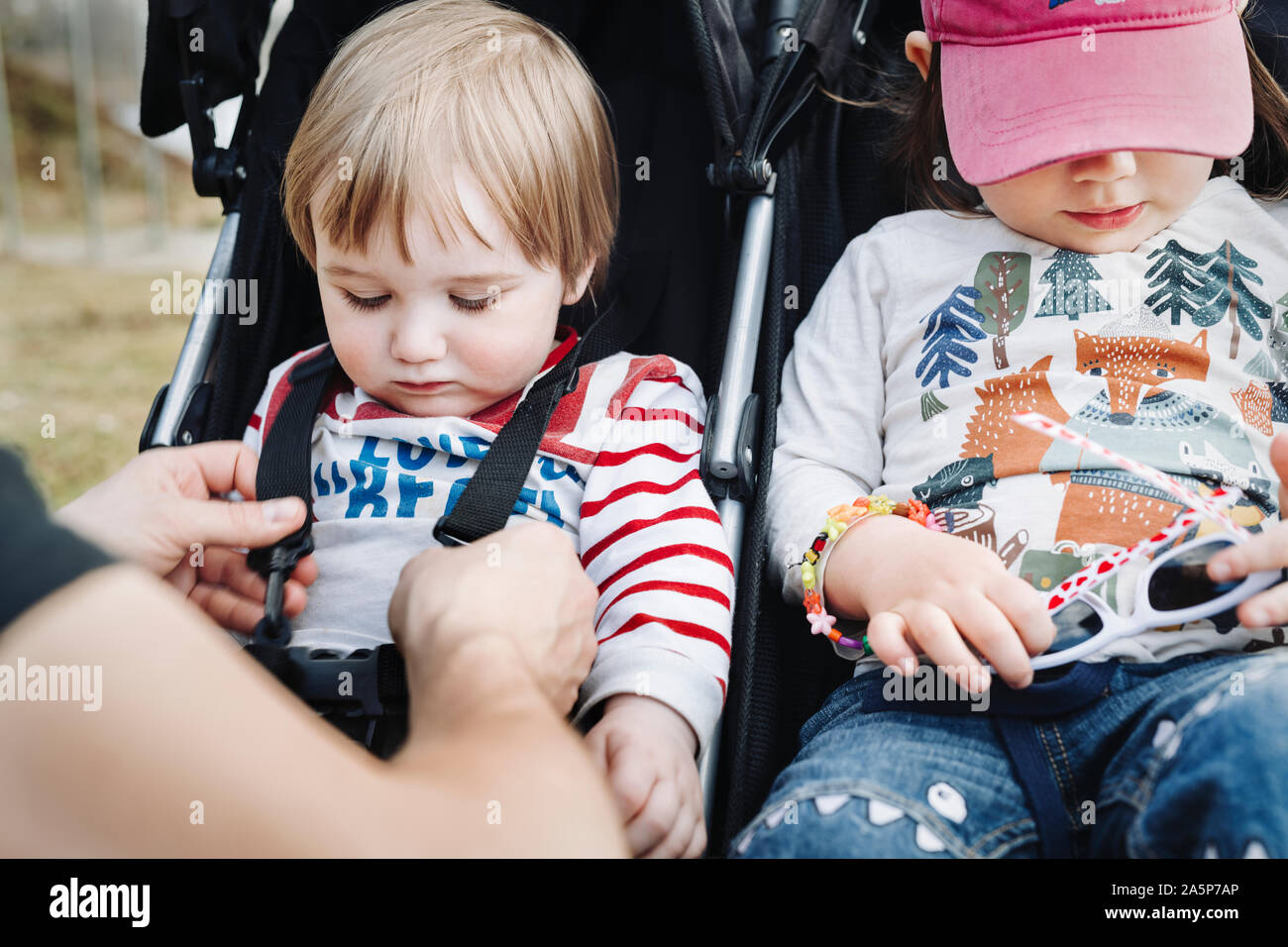 Father putting children into pram Stock Photo Alamy