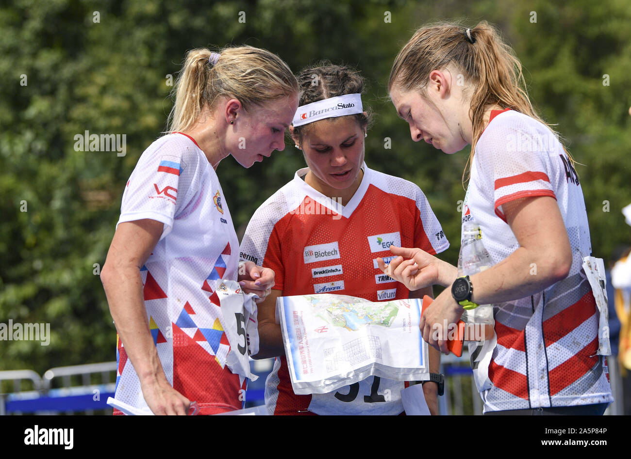 (191022) -- WUHAN, Oct. 22, 2019 (Xinhua) -- Gold medalist Anastasiia Rudnaia(L) of Russia, silver medalist Ursula Kadan (R) of Austria and bronze medalist Elena Roos of Switzerland communicate after finishing the women's individual long distance final of orienteering at the 7th International Military Sports Council (CISM) Military World Games in Wuhan, capital of central China's Hubei Province, Oct. 21, 2019. (Xinhua/Chen Yehua) Stock Photo